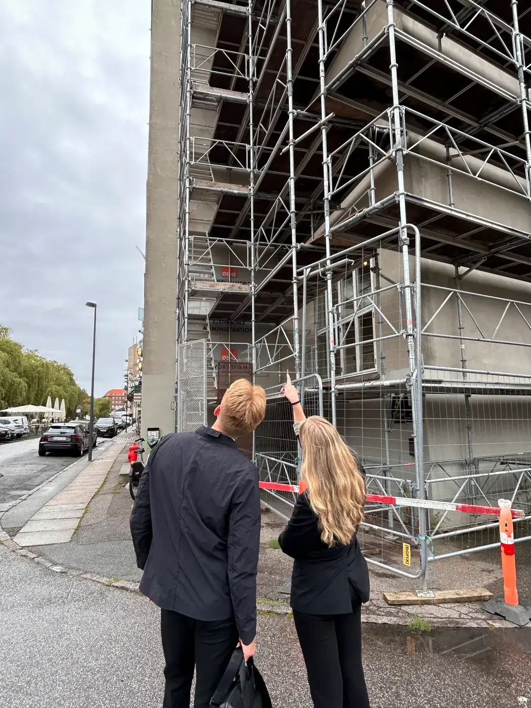 To medarbejdere fra EB Contractor ved en ejendom med stillads